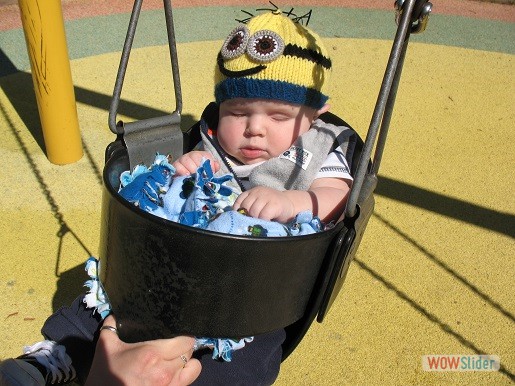 a baby boy is sitting on a swing